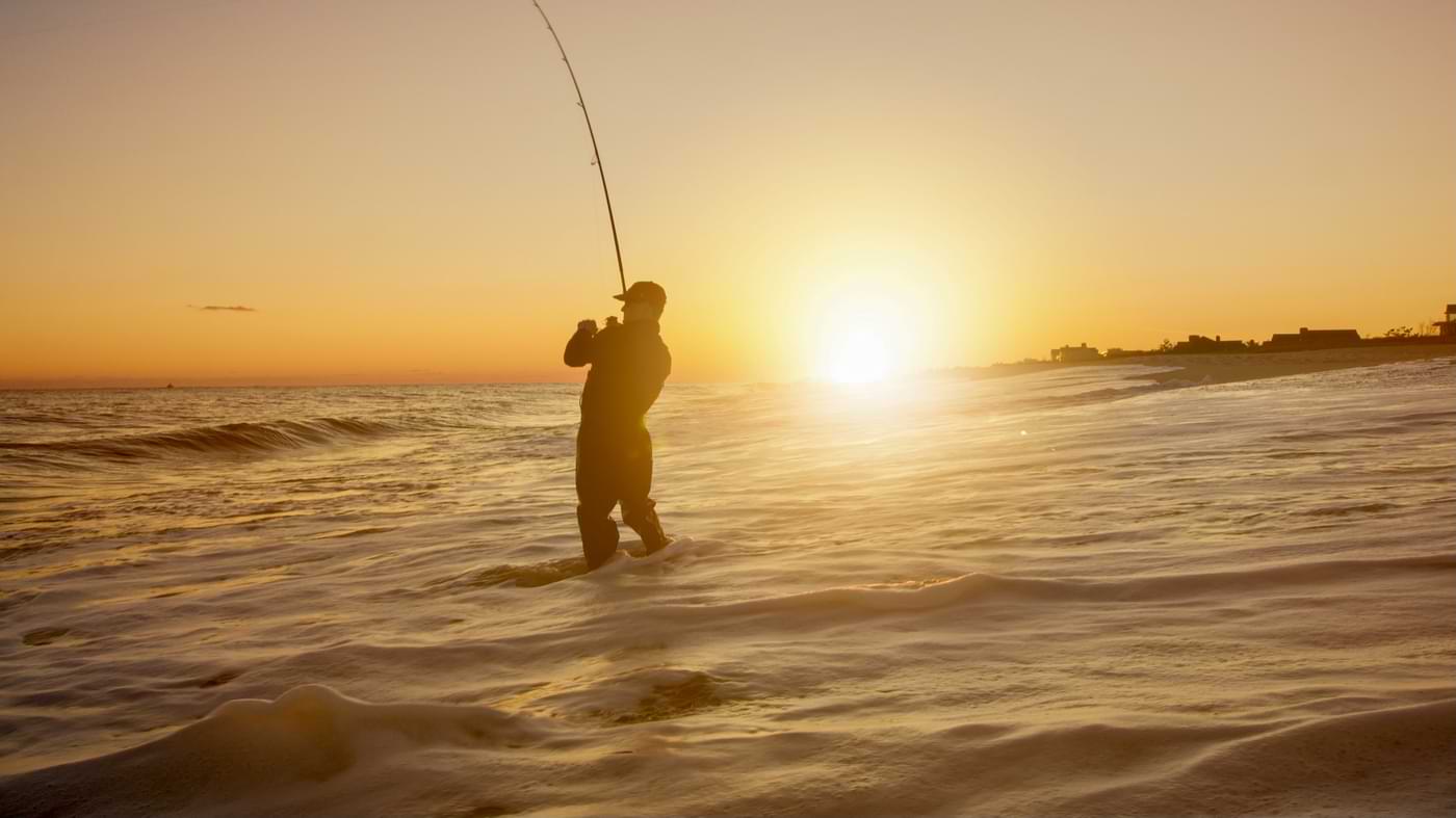 Angler vor Sonnenuntergang am Meer.